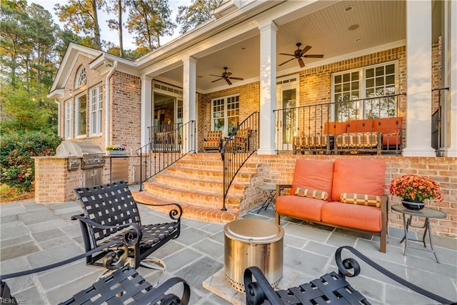 view of patio / terrace featuring covered porch, area for grilling, ceiling fan, and exterior kitchen