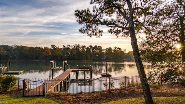 dock area with a water view and fence