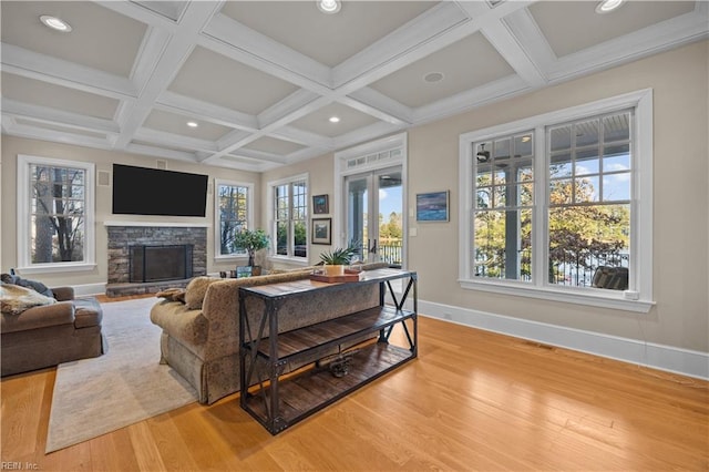 living room with beam ceiling, coffered ceiling, light wood-style floors, a fireplace, and baseboards