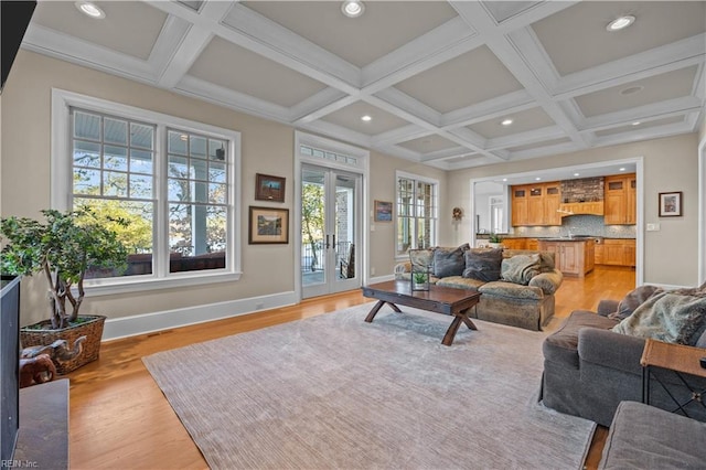 living area featuring light wood-style floors, french doors, baseboards, and coffered ceiling