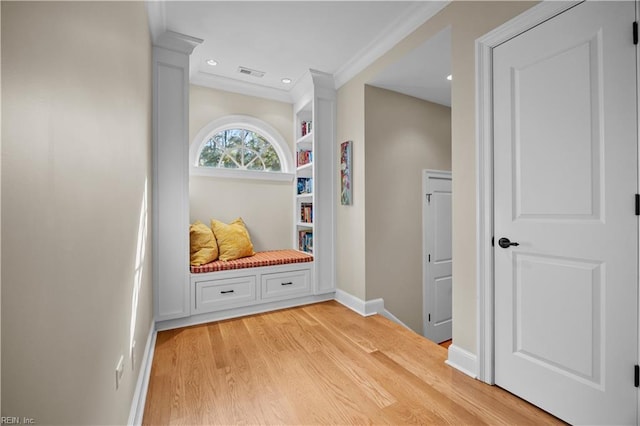 hallway featuring baseboards, visible vents, light wood-style flooring, recessed lighting, and crown molding