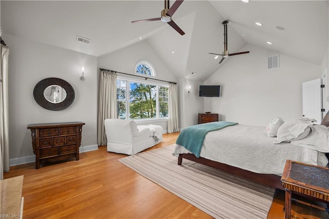 bedroom with light wood-type flooring, visible vents, baseboards, and high vaulted ceiling