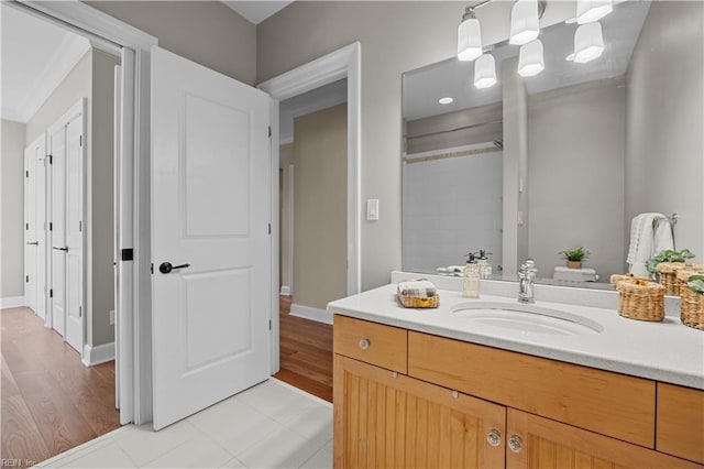 bathroom featuring tile patterned flooring, vanity, a shower, and baseboards