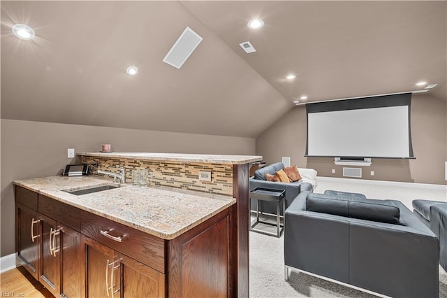 home theater room with vaulted ceiling, recessed lighting, baseboards, and a sink