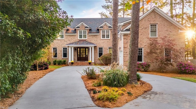 view of front of home featuring brick siding and concrete driveway