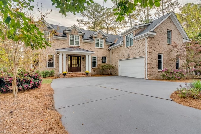 view of front of home featuring an attached garage, brick siding, and driveway