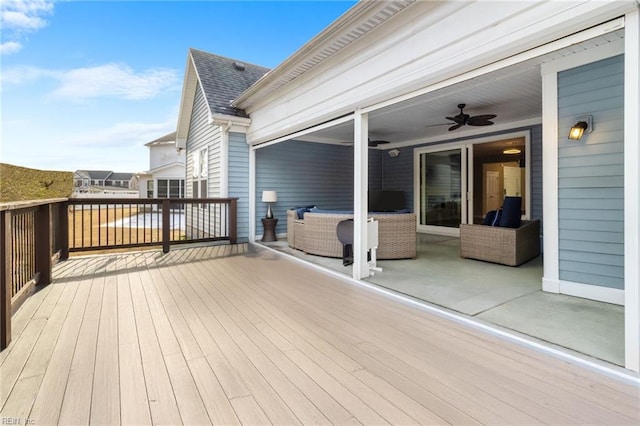 wooden deck with an outdoor hangout area and a ceiling fan