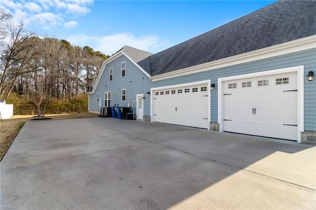 view of home's exterior featuring driveway, an attached garage, and roof with shingles