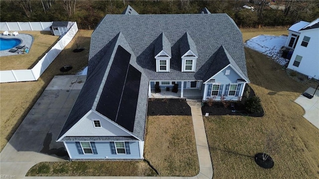 view of front of house featuring a fenced backyard, a front yard, roof with shingles, a fenced in pool, and a patio area