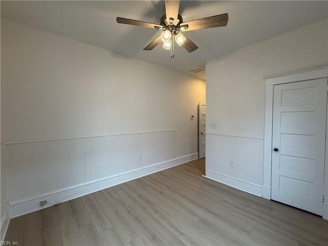 unfurnished room with visible vents, ceiling fan, baseboards, and wood finished floors