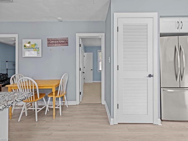 dining space with light wood-style floors, visible vents, and baseboards