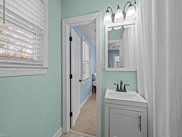 full bathroom with vanity and baseboards