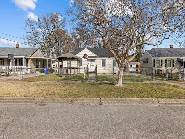 view of front facade featuring a fenced front yard, a gate, and a front lawn