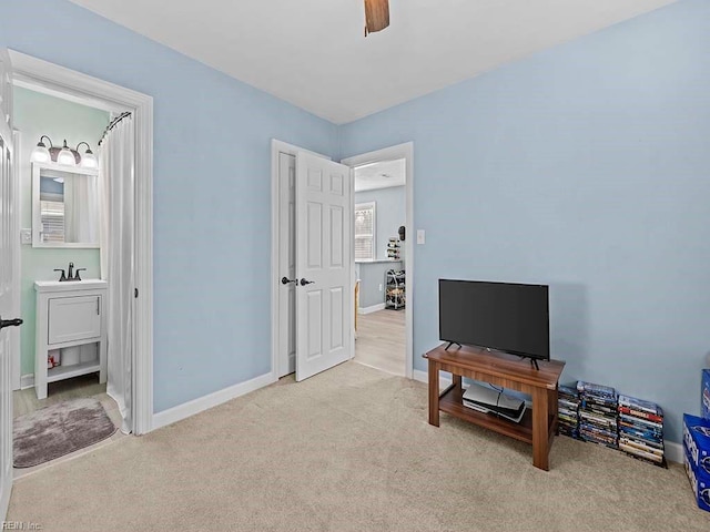 interior space featuring a sink, ceiling fan, carpet flooring, and baseboards