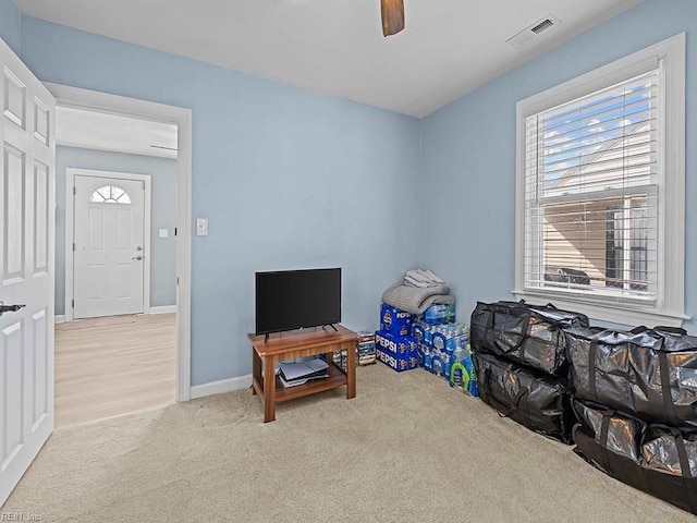 recreation room featuring a ceiling fan, carpet flooring, visible vents, and baseboards