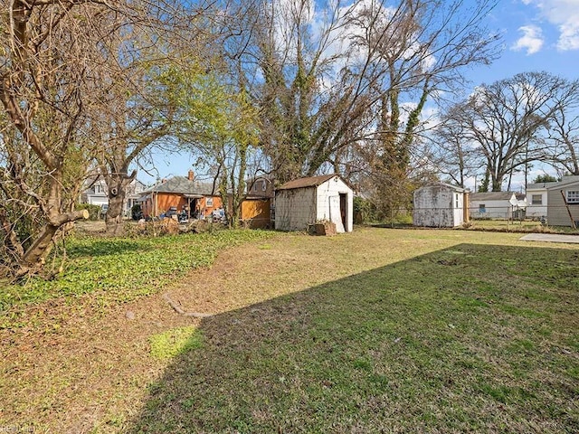 view of yard featuring fence, a storage unit, and an outdoor structure