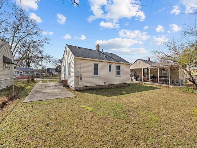 back of house with a yard, a chimney, crawl space, a patio area, and fence