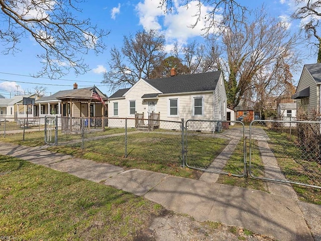 bungalow with a fenced front yard, a gate, a residential view, and a front lawn