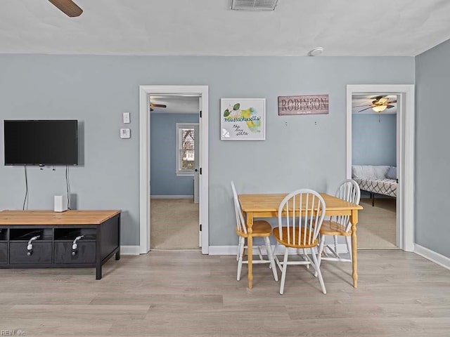 dining area featuring a ceiling fan, baseboards, and wood finished floors