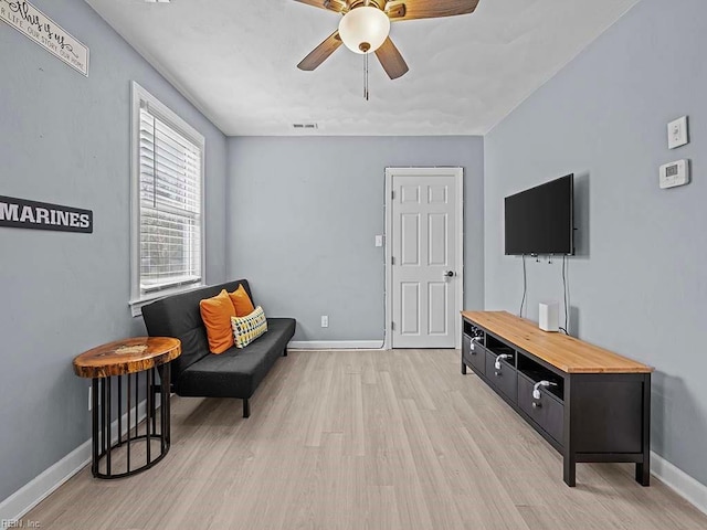 sitting room featuring light wood finished floors, ceiling fan, visible vents, and baseboards