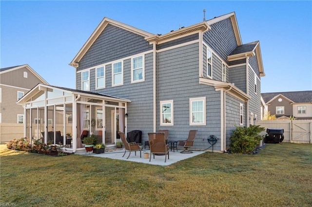 back of property featuring a yard, a sunroom, a patio, and fence