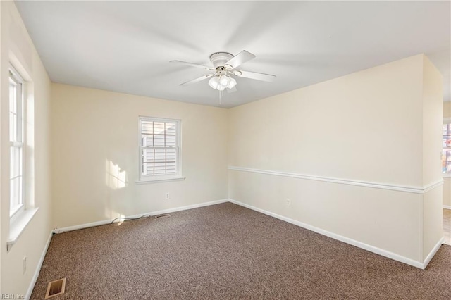 spare room featuring a ceiling fan, carpet flooring, visible vents, and baseboards