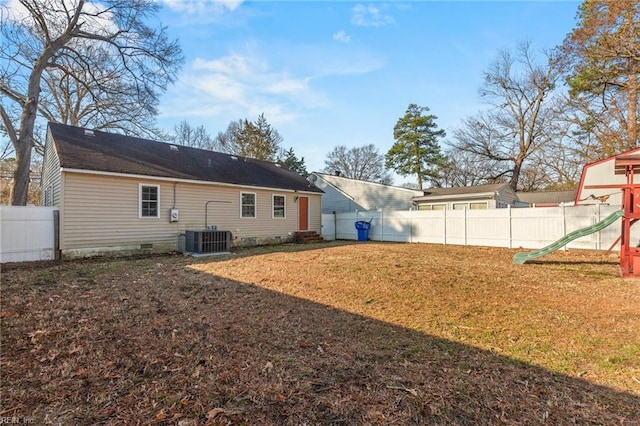 back of house featuring a playground, cooling unit, a fenced backyard, a yard, and crawl space