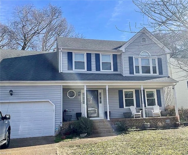 traditional-style home with an attached garage, covered porch, and a shingled roof