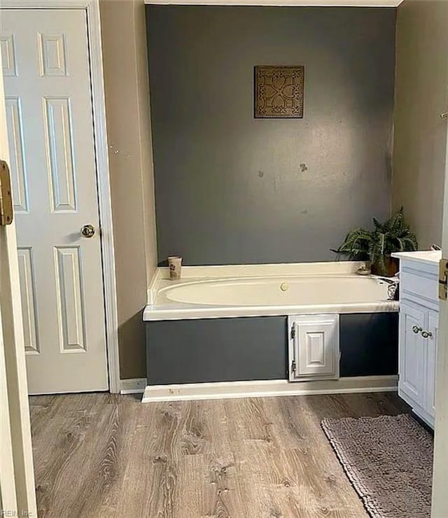 full bath featuring a garden tub and wood finished floors