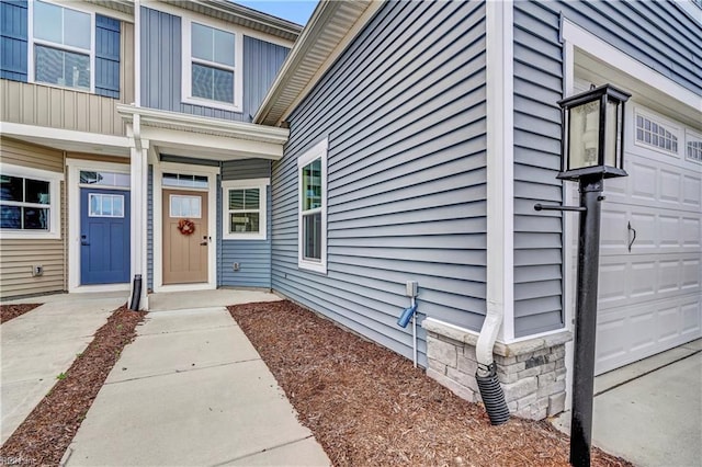 doorway to property featuring a garage and board and batten siding