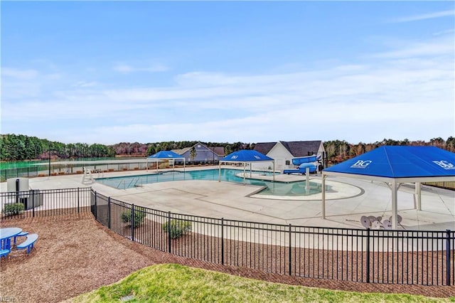 community pool with a patio and fence