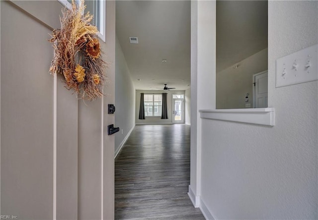 corridor with visible vents, wood finished floors, and baseboards