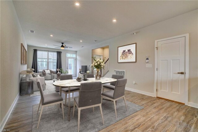 dining space featuring stairs, baseboards, and wood finished floors