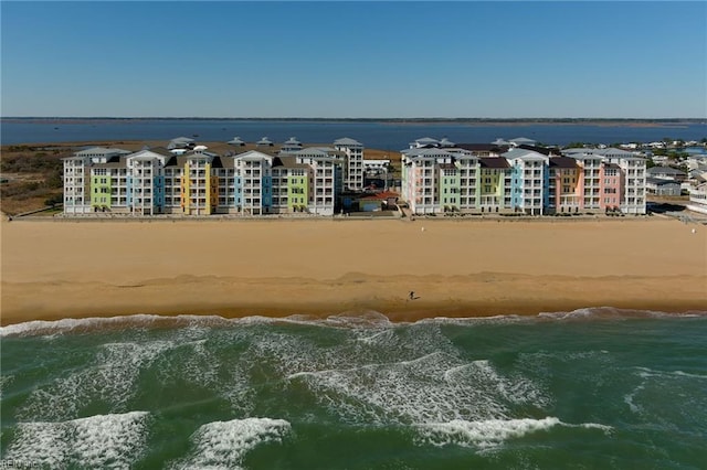 birds eye view of property with a water view and a beach view