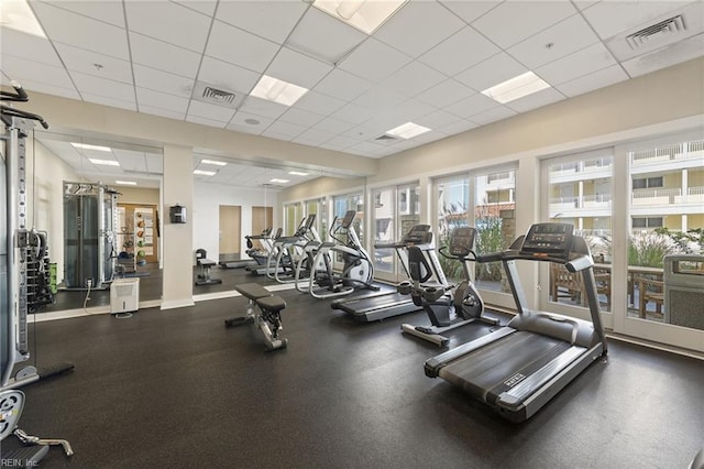 gym with a paneled ceiling and visible vents