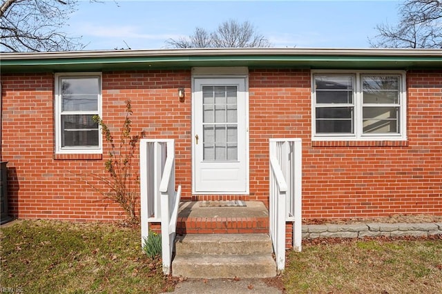 view of exterior entry featuring brick siding