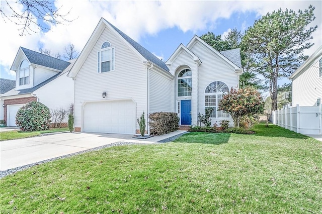 traditional home featuring a garage, concrete driveway, a front lawn, and fence