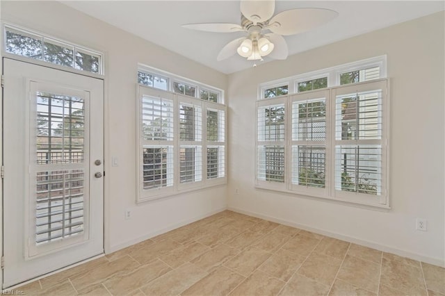 unfurnished sunroom with plenty of natural light and a ceiling fan