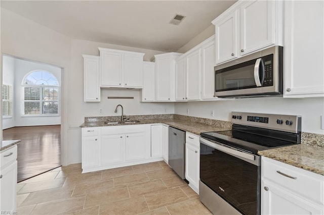 kitchen featuring a sink, visible vents, white cabinetry, appliances with stainless steel finishes, and light stone countertops