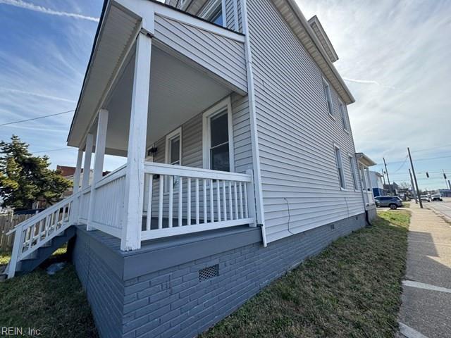 view of side of property featuring crawl space and covered porch