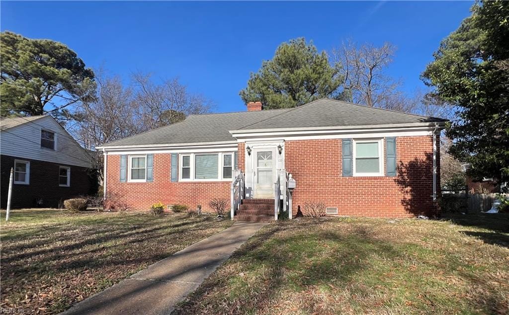 bungalow-style house with brick siding, crawl space, a chimney, and a front lawn