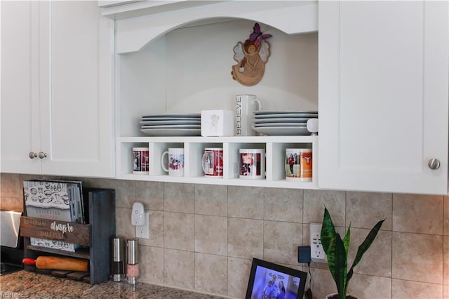 interior details with decorative backsplash and white cabinets