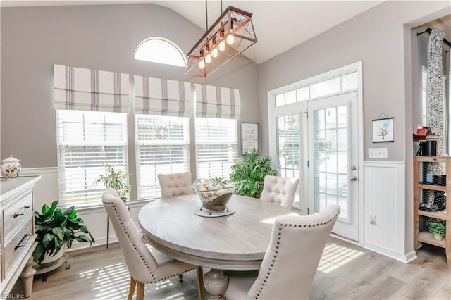 dining space featuring vaulted ceiling, light wood finished floors, and a wealth of natural light