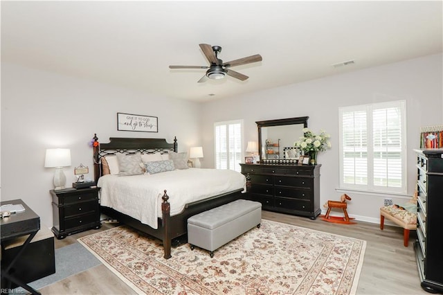 bedroom featuring visible vents, ceiling fan, baseboards, and light wood-style floors