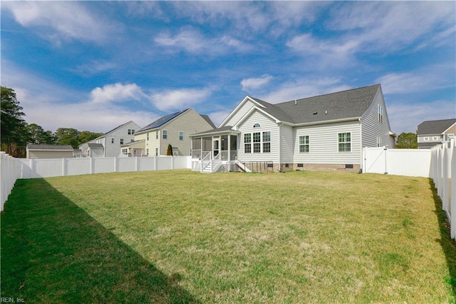 rear view of house with crawl space, a yard, a fenced backyard, and a sunroom