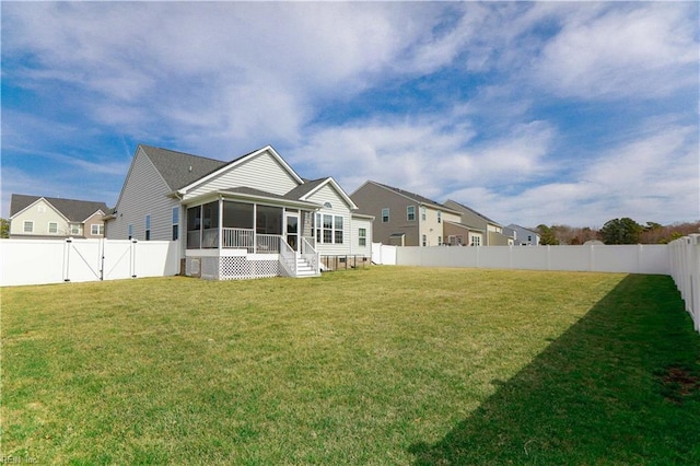 back of property featuring a gate, a fenced backyard, a yard, and a sunroom