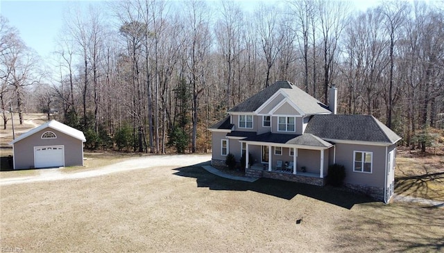 view of front of property with dirt driveway, a chimney, a detached garage, an outdoor structure, and a porch