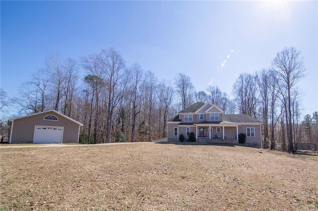 view of front facade featuring a garage, an outbuilding, and a front lawn