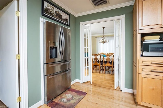 kitchen with a notable chandelier, visible vents, light wood-style flooring, appliances with stainless steel finishes, and ornamental molding