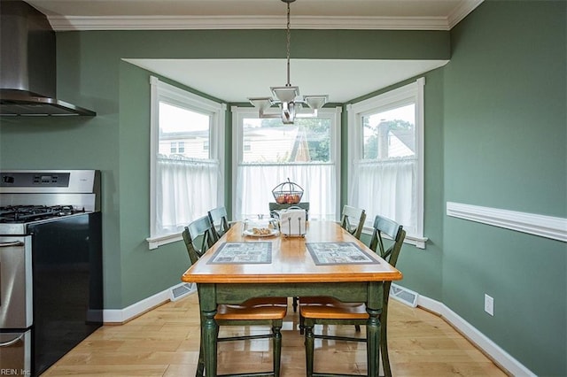 dining area featuring light wood-type flooring, visible vents, crown molding, and baseboards